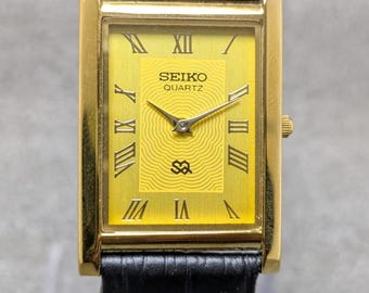 Reloj de pulsera japonés vintage Seiko Quartz Tank Slim Unisex, rectangular, restaurado, con esfera dorada.
