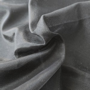 Könnte beinhalten: Schwarzes Netzgewebe mit einer feinen, gleichmäßigen Webart. Der Stoff ist weich und biegsam, mit einer leicht strukturierten Oberfläche.