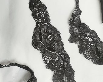 May include: Black lace trim featuring a delicate floral design. The lace is soft and flexible, making it perfect for adding a touch of elegance to any project.