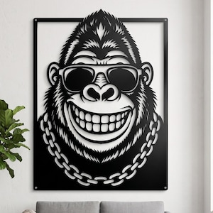 Puede incluir: Una pieza de arte mural de metal negro que muestra un gorila estilizado con gafas de sol y un collar de cadena gruesa. El gorila tiene una sonrisa amplia y está dentro de un marco rectangular con orificios de montaje en las esquinas.