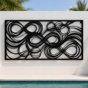 May include: A rectangular black metal wall art piece featuring an intricate, continuous pattern of overlapping loops, swirls, and circular lines enclosed within a solid black frame, mounted horizontally on a flat, smooth white surface.