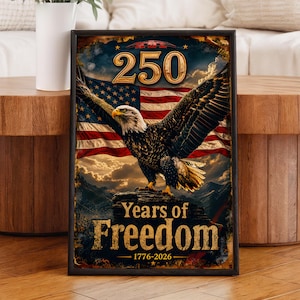 Op de afbeelding: Een ingelijst kunstwerk met een majestueuze Amerikaanse zeearend met uitgespreide vleugels tegen de achtergrond van de Amerikaanse vlag. Het kunstwerk herdenkt "250 jaar vrijheid" van 1776-2026, met vette letters en een vintage esthetiek.