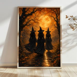 May include: A framed wall art print depicting three figures wearing pointed hats and long dark dresses walking along a path through a forest. The scene is illuminated by a large, glowing orange full moon set against a backdrop of autumn trees.