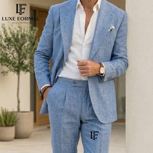 以下が含まれることがあります： ライトブルーのリネン製のスーツ。ジャケットとパンツのセットです。ジャケットは2つボタンで、ポケットチーフが付いています。パンツはプリーツフロントです。白いシャツと合わせています。「LUXE FORMAL RETRO APPAREL」のロゴが見えます。