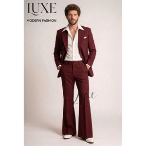 Peut inclure: Un costume bordeaux avec une chemise blanche. Le costume comprend un blazer et un pantalon évasé. L'image contient le texte "LUXE MODERN FASHION". Le modèle porte des chaussures blanches.