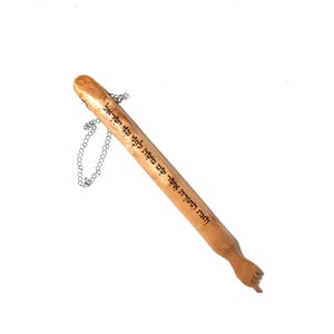 May include: A wooden mezuzah with a silver chain. The mezuzah is inscribed with Hebrew text.
