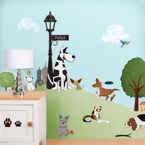 May include: A set of colourful wall decals featuring a dog walking down a street with a street lamp and a sign that says "Peter". There are other dogs, cats, and a bird on the decals. The decals are on a light blue wall with a white bedside table and lamp.