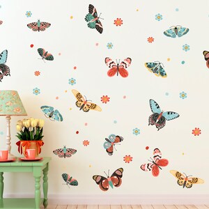 May include: A white wall with a variety of colorful butterfly wall decals. The butterflies are in different sizes and patterns, with some having red, orange, yellow, blue, and green colors. There are also small blue flower decals scattered throughout the wall.