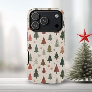 May include: A phone case with a festive Christmas tree pattern. The case features a repeating design of various trees in red, green, brown, and plaid on a cream background. The phone case has a black camera module.