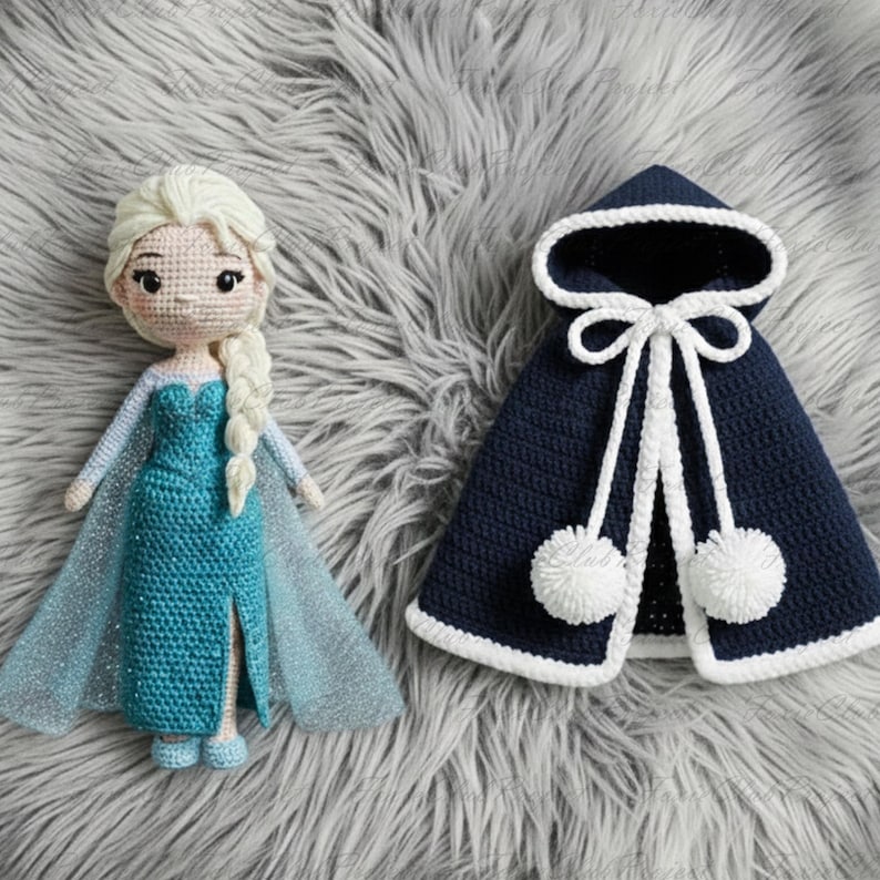 May include: A handmade crochet doll with a long blonde braid, wearing a teal dress and a sheer cape. Next to it is a navy blue hooded cape with white trim, a tie closure, and two white pom-poms. The items are on a gray, fluffy surface.