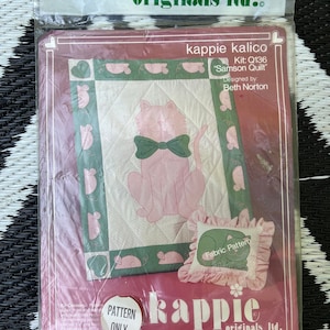 Puede incluir: Un kit de edredón "kappie kalico" vintage, con un gato rosa con una pajarita verde, rodeado de acentos verdes y rosas. El kit incluye un patrón para un "Samson Quilt" y una almohada a juego. El embalaje está sellado en plástico.
