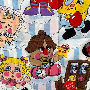 May include: A colorful fabric featuring a variety of cartoon characters, including a yellow character with a boxing glove, a brown character with a clock, and a pink character with a bow. The fabric has a blue and white striped background and the text "Bedtime Stories" is visible in the bottom right corner.