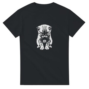 Könnte beinhalten: Schwarzes T-Shirt mit einem weißen, detailreichen Grafik eines grimmig dreinblickenden Kätzchens. Die Illustration des Kätzchens zeigt Fell und Gesichtsausdrücke. Das T-Shirt hat einen Rundhalsausschnitt und ist aus weichem Material.