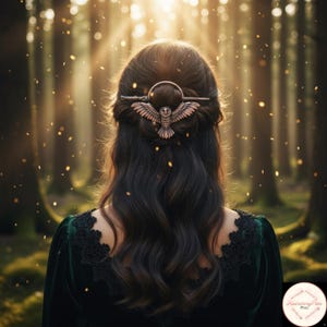 May include: A copper-toned hair clip with an owl motif, set in dark, wavy hair. The clip is placed at the back of the head, with the owl's wings displayed. The background shows a forest with sunlight filtering through the trees.