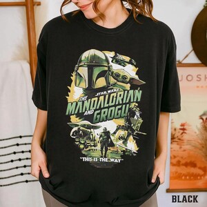 May include: Black t-shirt with a Star Wars graphic featuring the Mandalorian and Grogu. The design includes the Mandalorian's helmet, Grogu, and the phrase "THIS IS THE WAY."