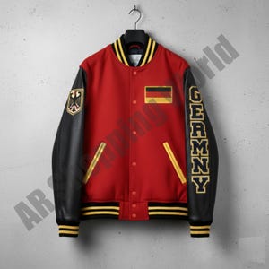 Pode incluir: Casaco universitário vermelho com mangas pretas, com a palavra "GERMANY" em letras douradas numa manga. Inclui patches da bandeira alemã e um brasão. O casaco tem acabamento listrado amarelo e preto.