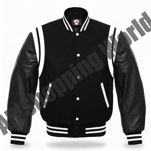 Puede incluir: Chaqueta universitaria negra con detalles blancos. Cuenta con mangas de cuero negro, cuello blanco y rayas blancas en los puños y el dobladillo. La chaqueta tiene botones blancos y un pequeño logo en el pecho.