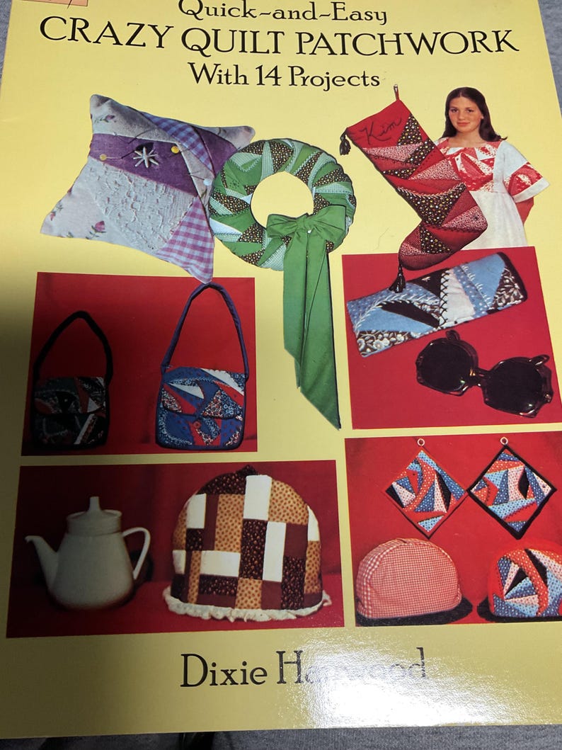 May include: A book titled "Quick-and-Easy Crazy Quilt Patchwork with 14 Projects" by Dixie Harwood. The cover features a variety of patchwork projects, including a pillow, a wreath, a stocking, a purse, a pair of sunglasses, a teapot cozy, and pot holders.