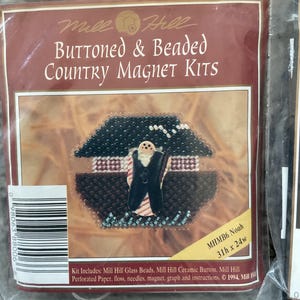 以下が含まれることがあります： Mill Hill Buttoned & Beaded Country Magnet Kit。家の中の人物のデザインが特徴です。キットには、ガラスビーズ、セラミックボタン、ミシン目入り紙、フロス、針、磁石、説明書が含まれています。キットのサイズは79cm x 61cmです。