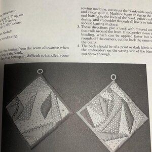 May include: Two black and white quilted pot holders with a geometric pattern. The pot holders are made with two layers of batting and are designed to be practical and decorative.