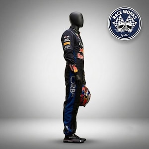 May include: A black and blue racing suit worn by a mannequin, featuring various sponsor logos including Mobil, Ava Trade, and Red Bull. The suit has long sleeves, a high collar, and is paired with a multi-colored racing helmet held in one hand.