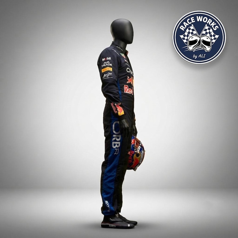 May include: A black and blue racing suit worn by a mannequin, featuring various sponsor logos including Mobil, Ava Trade, and Red Bull. The suit has long sleeves, a high collar, and is paired with a multi-colored racing helmet held in one hand.