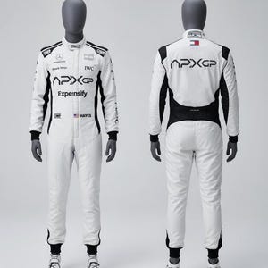 Puede incluir: Mono de carreras blanco con detalles en negro, exhibido en un maniquí. El mono presenta logotipos de patrocinadores, incluyendo "APXGP" y "Expeensify". Tiene mangas largas, cremallera frontal y pantalones a juego. El maniquí lleva guantes negros y zapatos de carreras blancos.