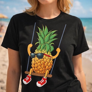 Puede incluir: Camiseta negra con un dibujo animado de piña con gafas de sol y zapatillas rojas, balanceándose en un columpio. La piña tiene una parte superior verde y un cuerpo amarillo. El fondo muestra una escena de playa.