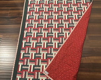 Trapunta decorativa fatta a mano con blocchi natalizi vintage e bordo verde scintillante.