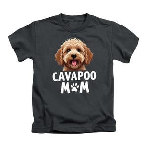 May include: A dark grey t-shirt with a Cavapoo dog illustration and the text "CAVAPOO M&M" in white. The dog has brown fur and a pink tongue. The shirt is a kids' size.