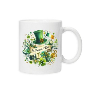 May include: White ceramic mug with a St. Patrick's Day design. The design features a green leprechaun hat, an Irish flag, shamrocks, and the text "St. Patrick's Day" on a banner. The mug has a white handle.