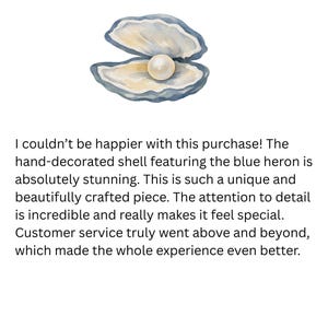 Pu&ograve; includere: Un'illustrazione ad acquerello di un guscio di ostrica aperto con una perla bianca, rotonda e liscia, all'interno. Il guscio presenta sfumature di blu, grigio e crema, con un bordo smerlato testurizzato e una finitura interna madreperlacea.