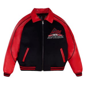 May include: A black and red varsity jacket featuring a fold-down collar, a full-length front zipper, and long sleeves. The chest displays an embroidered logo with the text "NEW YORK 1975 CLASSIC AVIREX". It includes two side pockets and ribbed cuffs.