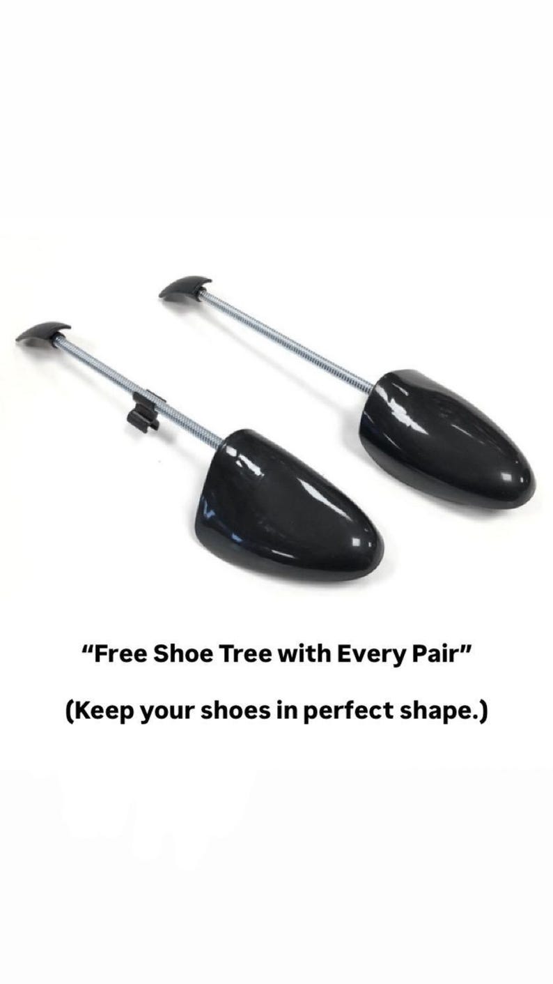 Pode incluir: Duas formas de sapato pretas com design de mola. As formas de sapato t&ecirc;m uma biqueira de pl&aacute;stico preta e uma haste de metal com uma pega. O texto "Free Shoe Tree with Every Pair" est&aacute; abaixo.