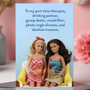 May include: A greeting card with the text "To my part-time therapist, drinking partner, gossip dealer, mood lifter, photo-angle director, and absolute treasure." Two dolls are seated on a yellow sofa, holding drinks. The background is light blue and pink.