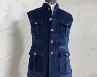 May include: A navy blue velvet vest with four front pockets and a mandarin collar. The vest has silver buttons and is displayed on a mannequin. The TextThrive logo is visible in the upper left corner.