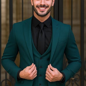 May include: A three-piece teal suit with a black shirt and tie. The suit jacket is buttoned, and the vest is visible. The person is smiling. The image includes the text "TEXTHRIVE" at the bottom.