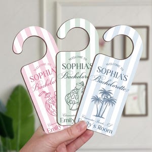 May include: Three vertical door hangers with hook tops, featuring pastel pink, mint green, and light blue stripes. Each hanger displays the text Welcome to Sophia's Bachelorette, Clearwater Beach, FL, and Emily's Room, with illustrations of a coconut drink, a seashell, and palm trees.