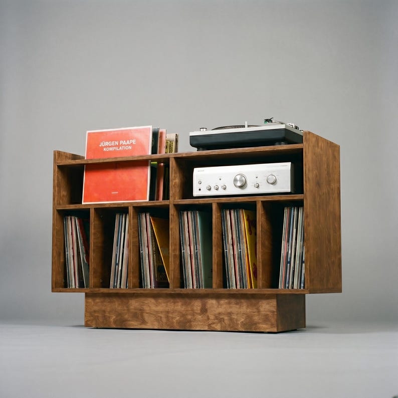 Low angled view of Groove No.3 walnut vinyl storage console with turntable shelf, open receiver space, warm wood grain, and organized record compartments.