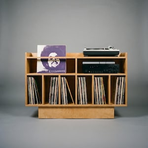 Front view of Groove No.3 record player stand in natural birch plywood with turntable platform, amplifier shelf, and six vertical vinyl record storage sections.