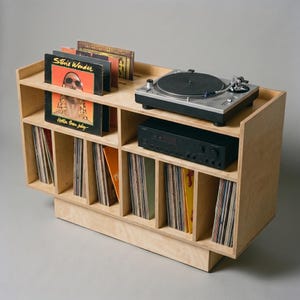 Top angled view of Groove No.3 birch plywood record player stand with turntable, amplifier shelf, front-facing album display, and six vinyl storage compartments.