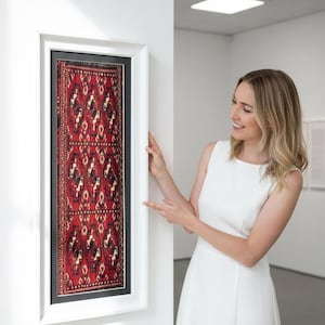 Arte de parede em lã, tecida à mão, com motivos de estrelas e emoldurada.