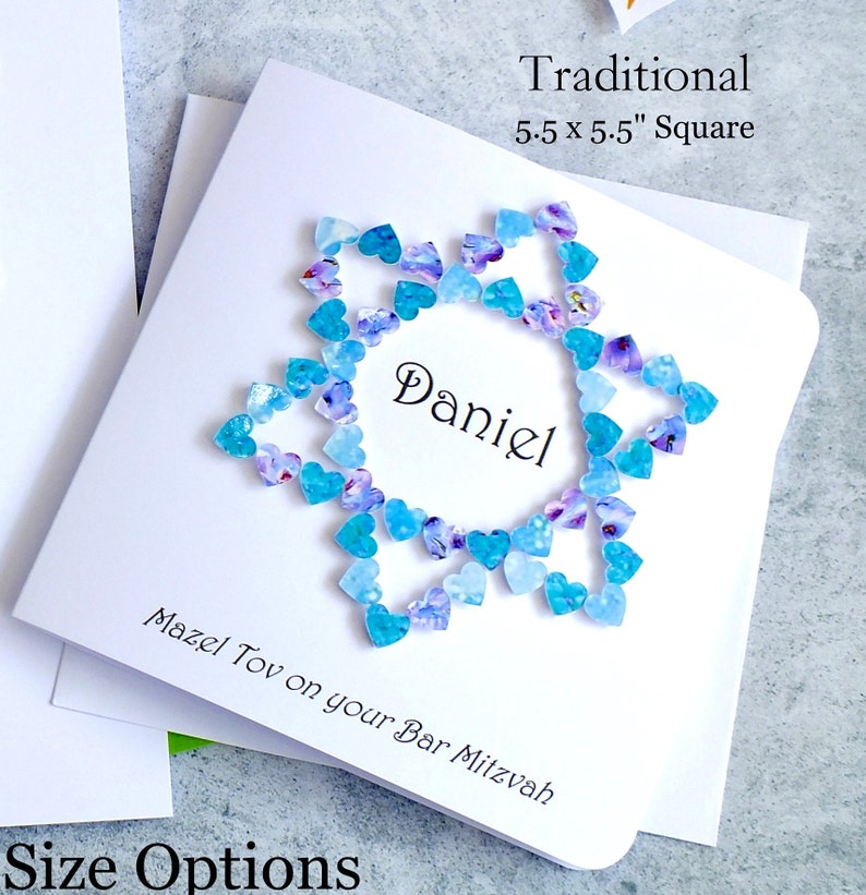 May include: A white card with a blue and purple heart design surrounding the name "Daniel". The card reads "Traditional 5.5 x 5.5" Square" and "Mazel Tov on your Bar Mitzvah".