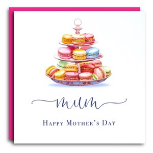 May include: A white card with a pink border features a watercolor illustration of a three-tiered cake stand filled with colorful macarons. The text "mum" is written in cursive script above the text "Happy Mother's Day".