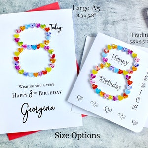 May include: A white card with a colorful number eight made of hearts. The card says "Wishing you a very happy 8th birthday Georgina" and "Today". The card is available in two sizes: Large A5 (8.3 x 5.8 inches) and Traditional (5.5 x 5.5 inches).