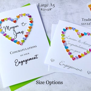 May include: Two engagement cards with a heart made of colorful paper hearts. The larger card is 8.3 inches by 5.8 inches and says "Maegan & James Congratulations on your Engagement". The smaller card is 5.5 inches by 5.5 inches and says "Lauren & Harry Congratulations on your Engagement".
