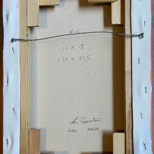 May include: The back of a rectangular canvas stretched over a light-colored wooden frame with metal staples. A wire is attached for hanging. Handwritten text includes #15, 12 x 18, 17.5 x 23.5, a signature, 2026, and F0629 on the canvas surface.
