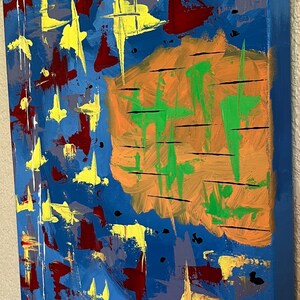Pu&ograve; includere: Un dipinto astratto su tela rettangolare con uno sfondo blu vibrante. La composizione include forme gialle simili a stelle sparse, macchie rosso scuro e una grande forma arancione centrale sovrapposta a pennellate verticali di colore verde.