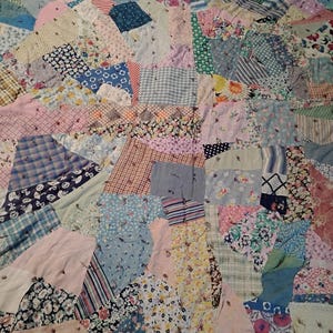Cutter knotted comforter 78&quot; x 66&quot; variety of floral and geometric fabrics in different sizes and shapes. Bordered, Major back hole 1940s