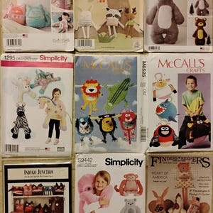 May include: A collection of sewing pattern envelopes featuring various stuffed animal designs. The patterns include animals like bunnies, bears, foxes, and other creatures. The envelopes are from Simplicity, McCall's, and Finders Keepers.